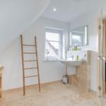 Badezimmer mit Dusche, Waschbecken und Sauna.