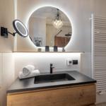 Badezimmer mit Waschtisch, Spiegel und Handtuchheizung.
