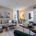 Wohn- und Essbereich mit Sofa, Tisch und Blick in Schlafzimmer