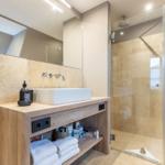 Badezimmer mit Dusche, Waschtisch und Spiegel