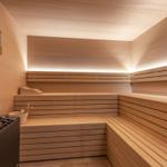 Sauna mit Holzbanken und Beleuchtung an der Wand