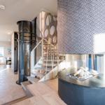 Haus mit moderner Treppe und Kamin im Wohnbereich.
