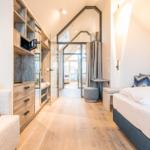 Schlafzimmer mit Bett, Schrank und Glaswand zur Terrasse