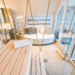 Sauna mit Holzbank, Seeblick und Badewanne im Hintergrund