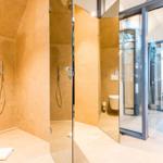 Dusche mit Duschbrause, Toilette und Waschbecken im Badezimmer