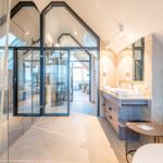 Bad mit Dusche, Waschbecken und Sitzgelegenheit