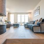 Wohnzimmer mit Sofa, Kamin und Holzboden