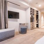 Schlafzimmer mit Bett, Sofa, TV und Kleiderschrank.
