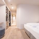 Schlafzimmer mit Bett, Kleiderschrank und Holzboden.