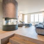 Wohnbereich mit Kamin, Sofa und Terrasse