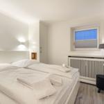 Bedroom with double bed, window, and wall picture.