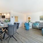 Living and dining area with kitchenette, sofa, and chairs.