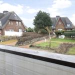 Rote Backsteinhäuser mit grauen Dächern und gepflegten Gärten.