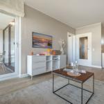 Wohnzimmer mit Essbereich und Balkon. Holzboden und modernes Mobiliar.