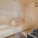 Sauna mit Holzbank, Eimer und Steine