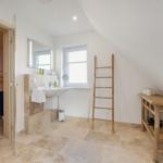 Badezimmer mit Dusche, Waschbecken und Sauna im Anbau.