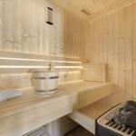 Sauna mit Holzbank, Eimer und Steine