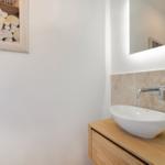 Waschbecken mit Spiegel und Seetangdekoration an der Wand.