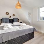 Schlafzimmer mit Doppelbett, Fenster und Deckenleuchte.