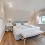 Bedroom with double bed, wooden floor, and window
