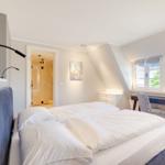 Bedroom with double bed, desk, and view of dormer window.