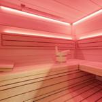 Sauna with wooden benches and wooden bucket with ladle.