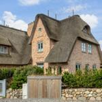 House with thatched roof and stone wall enclosure