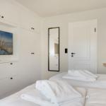 Schlafzimmer mit Bett, TV und Spiegeln