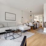 Wohnzimmer mit Sofa, Kamin und Essbereich.