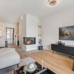 Wohnzimmer mit Kamin, TV und Essbereich.