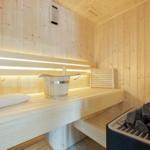 Sauna mit Holzbänken, Waschbecken und Steinen
