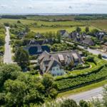 Haus mit Dachstuhl und Garten in ländlicher Umgebung mit Straßen und Feldern.