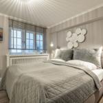 Schlafzimmer mit Bett, Fenster, Wanddekoration und Fernseher an der Wand.