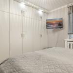 Schlafzimmer mit großem Schrank, Bett und Wand-TV.