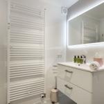 Badezimmer mit Waschbecken, Spiegel und Heizkörper