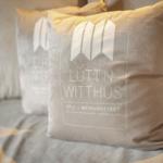 Kissen mit Logo auf Sofa in Wohnraum