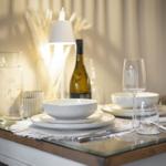 Tisch mit Geschirr, Weinflasche und Glas