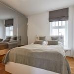 Schlafzimmer mit Bett, Spiegelschrank und Fenster mit Rollladen.