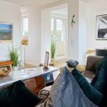 Wohnzimmer mit Sofa, Fernseher und Fenster zur Terrasse