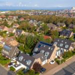 Dorf mit Häusern, Grünflächen und Blick aufs Meer