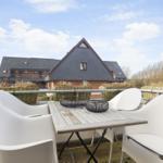Terrace with white table and chairs, view of a house with slate roof.