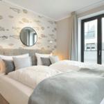 Bedroom with fish pattern wall, bed, and window