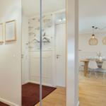House with dining area, wooden floor, and glass wall. Wall with fish motif and modern lamps.
