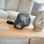 Wooden table with fish figurine, candle holders, and guest book in front of a sofa.