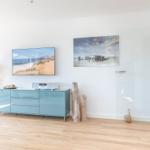 Living room with TV, media console, and glass wall