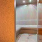 Sauna mit Sitzbank, Glaswand und Deckenbeleuchtung