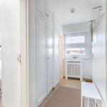 Flur mit Kleiderschrank, Fenster und Badezimmer. Links Schlafzimmer mit Doppelstockbett.