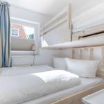 Zimmer mit Doppelbett und Hochbett, Fenster mit Vorhängen.
