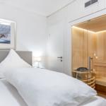 Schlafzimmer mit Doppelbett und integrierter Sauna.