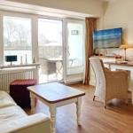 Living room with sofa, table, and TV. Access to terrace with tables and chairs.